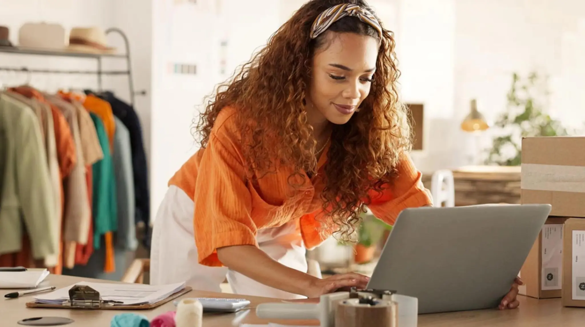 Female business owner working at her laptop in her shop.