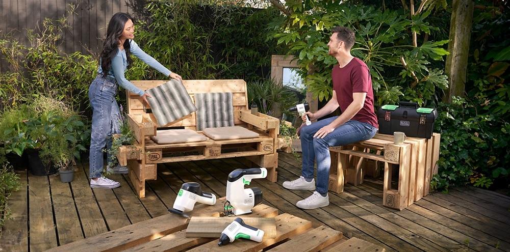 People using tools to build furniture out of wood pallets 