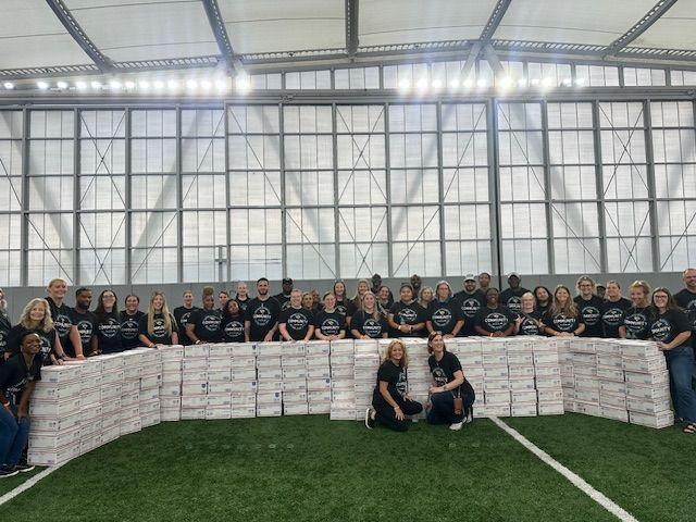 Volunteers posed behind stacks of finished care boxes.