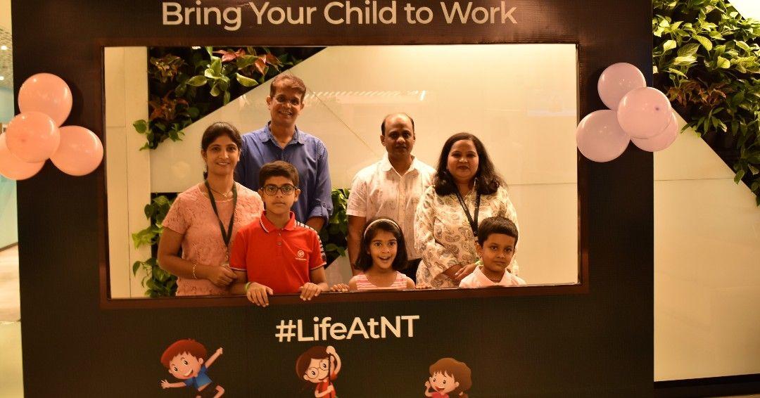 Employees and their children behind a photo prop