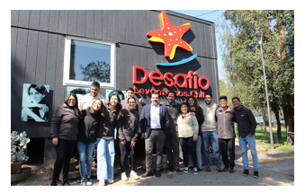 People posed in front of a building "Desafio" logo on the side.