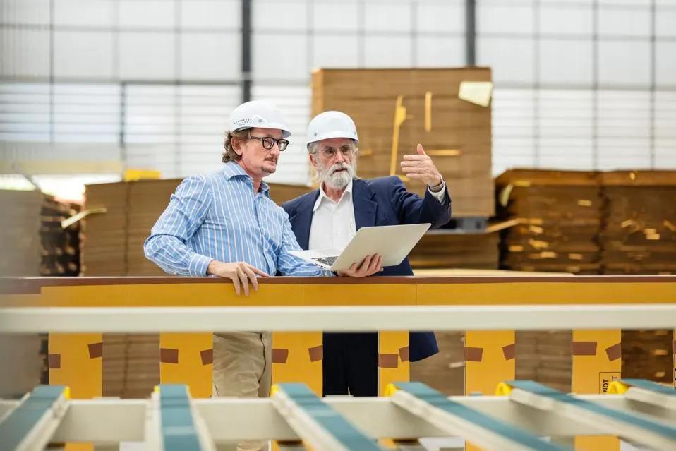 Two people in hard hats in a manufacturing scene.