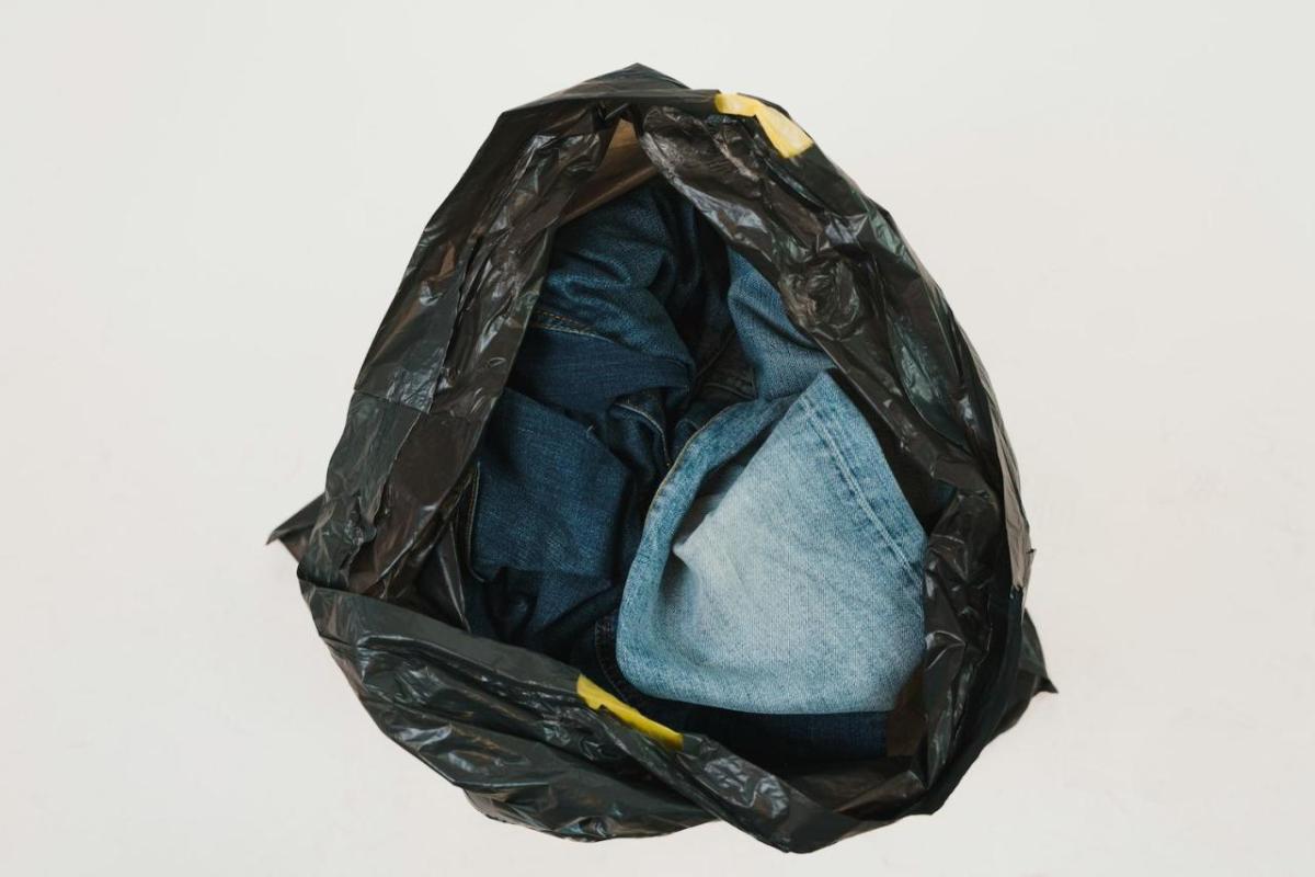 A black garbage bag with jeans inside