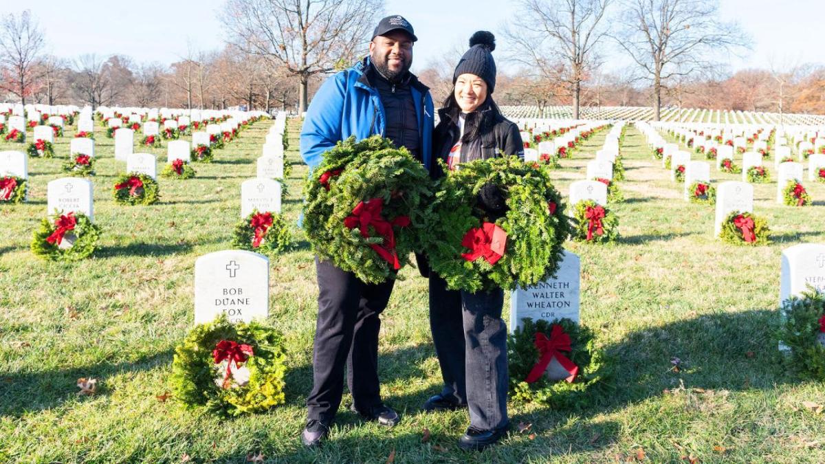 two people standing with wreaths 