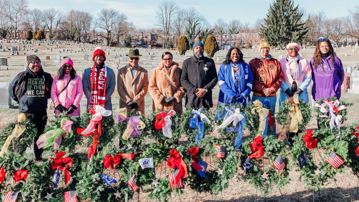 group posing with decorated wreaths 