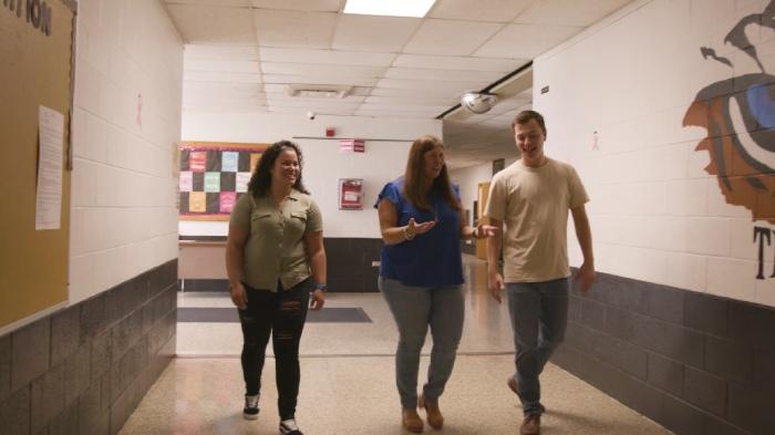 Martesi and two of her former Tiger Tech students walking through a corridor 