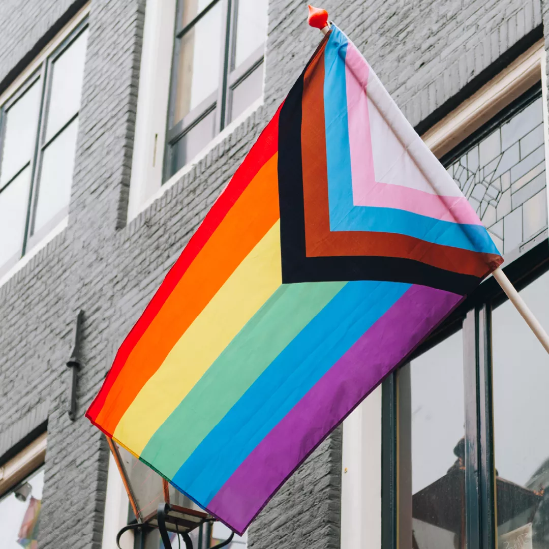 LGBTQ flag flying on a building