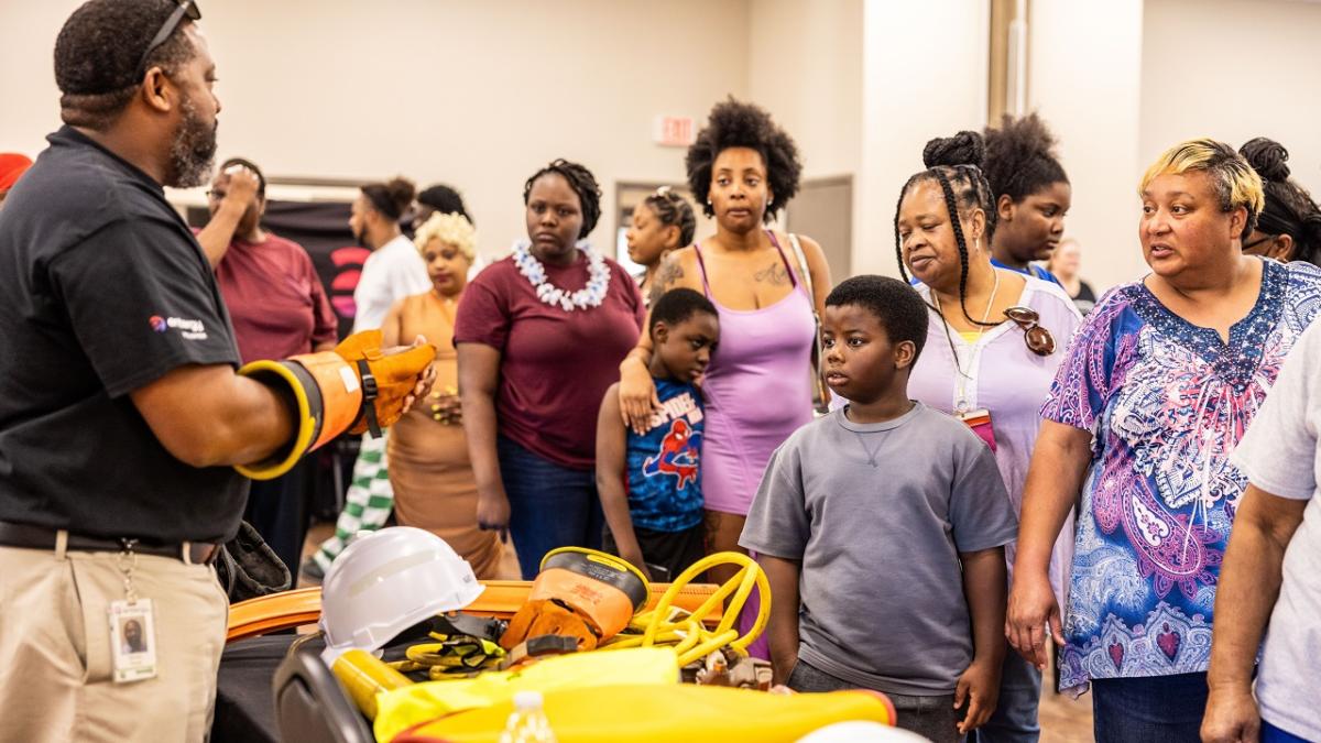 A volunteer showing equipment used in their job to attendees.