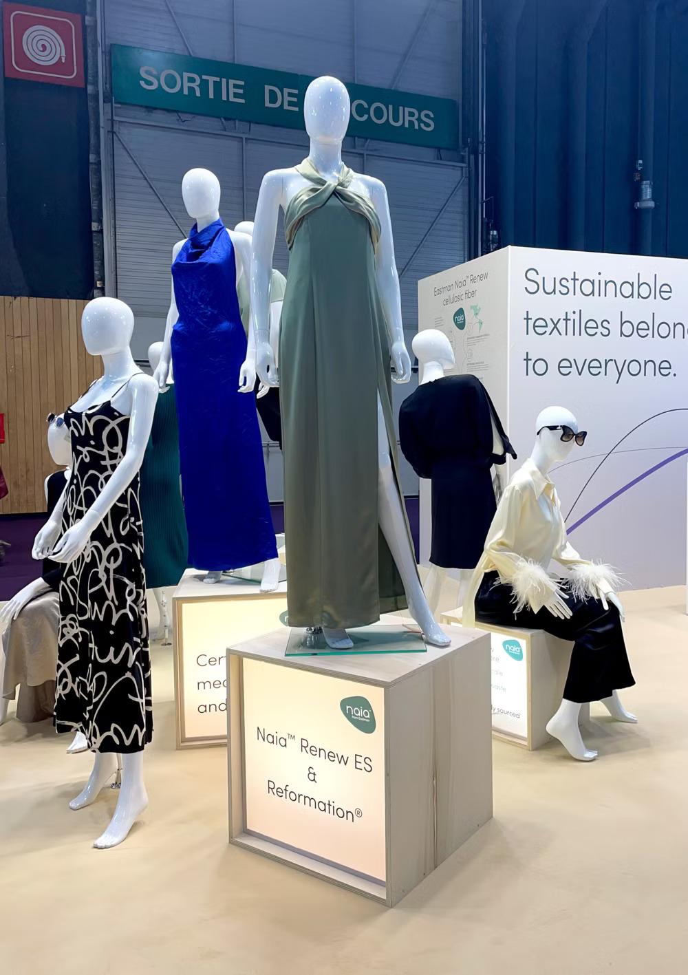 Manequins in different dresses. A display "Sustainable textiles belong to everyone." behind them.