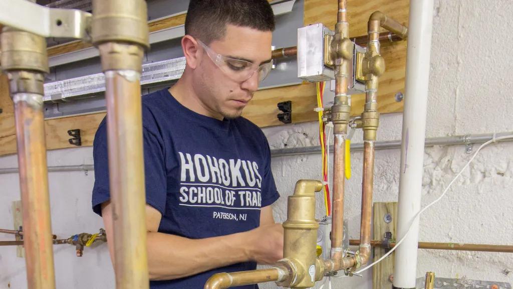 A person working on water piping.