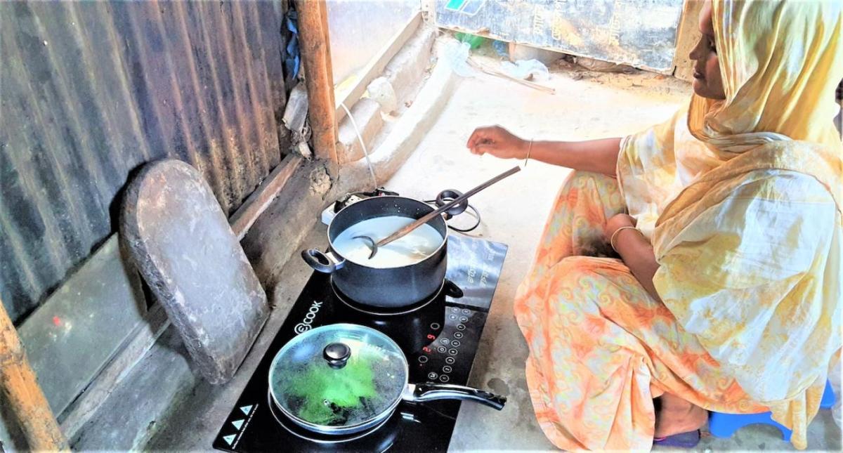 Person cooking with two pans on an electric stove