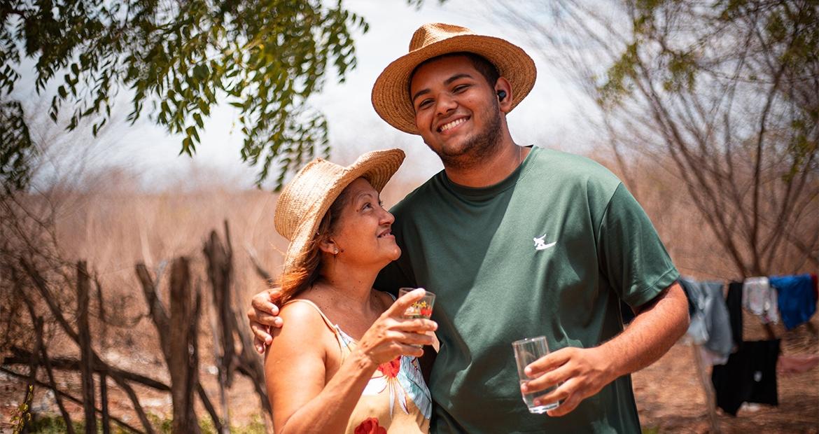 Two people standing together with glasses of water