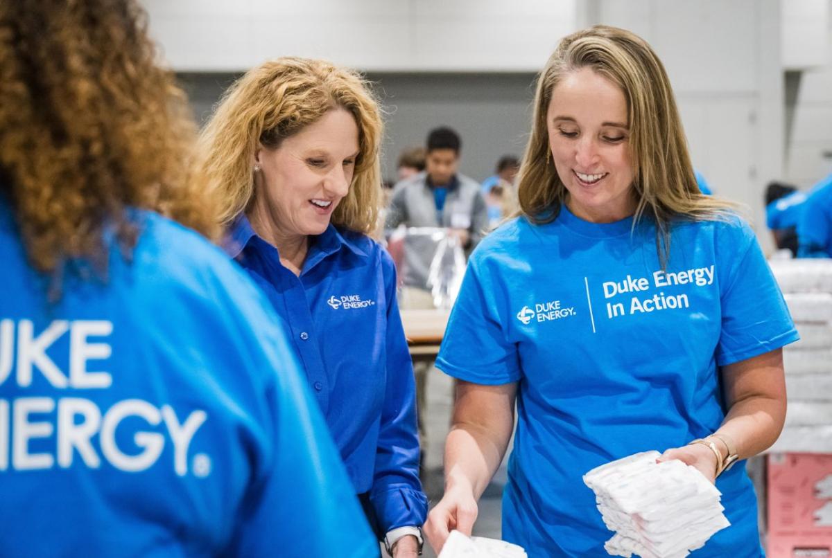 Smiling volunteers sorting diapers.