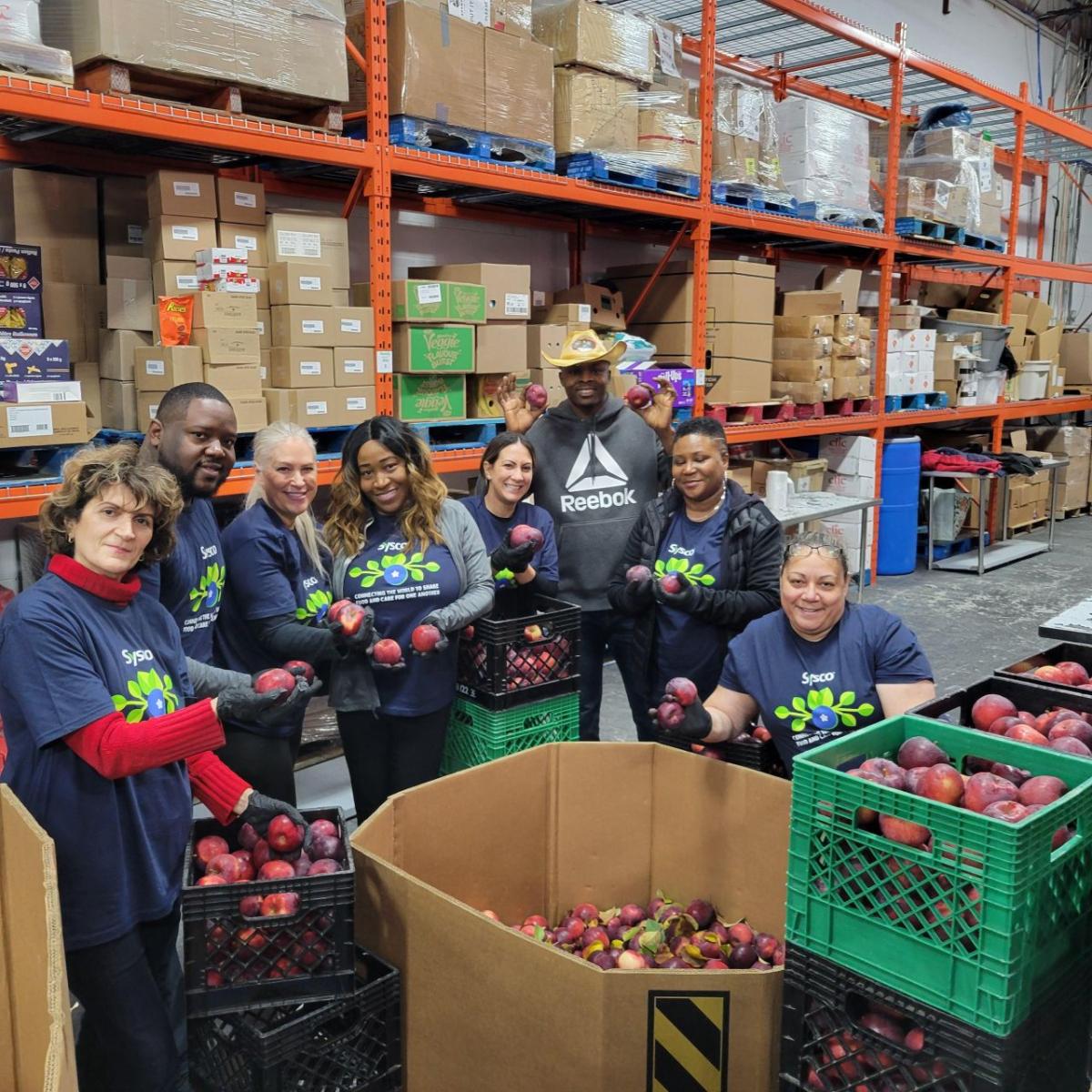 people standing with crates of apples