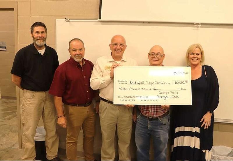 Five people holding an oversized check