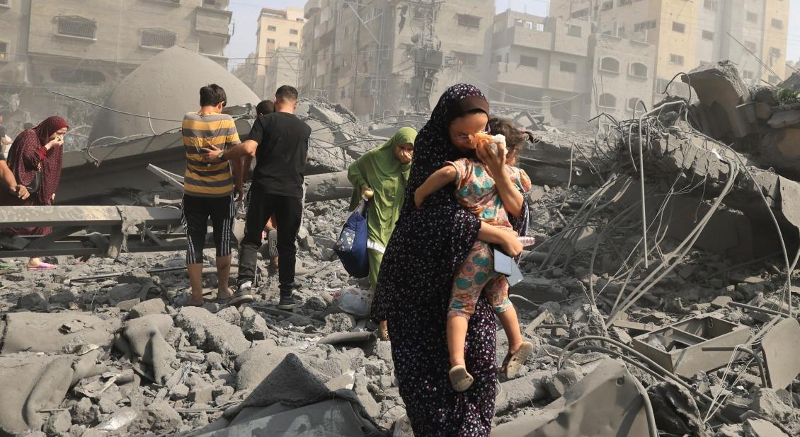 Palestinians evacuate following an airstrike on a mosque in Gaza City. / Photo by Mahmud HAMS, AFP 