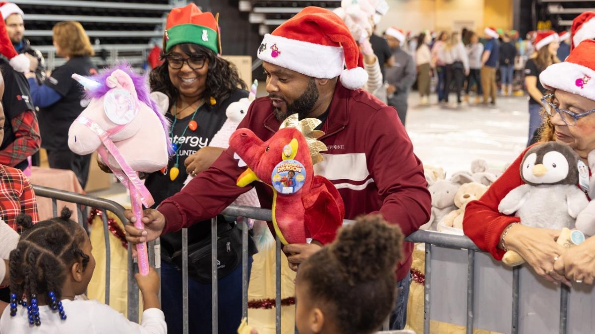 A volunteer handing out toys to children.