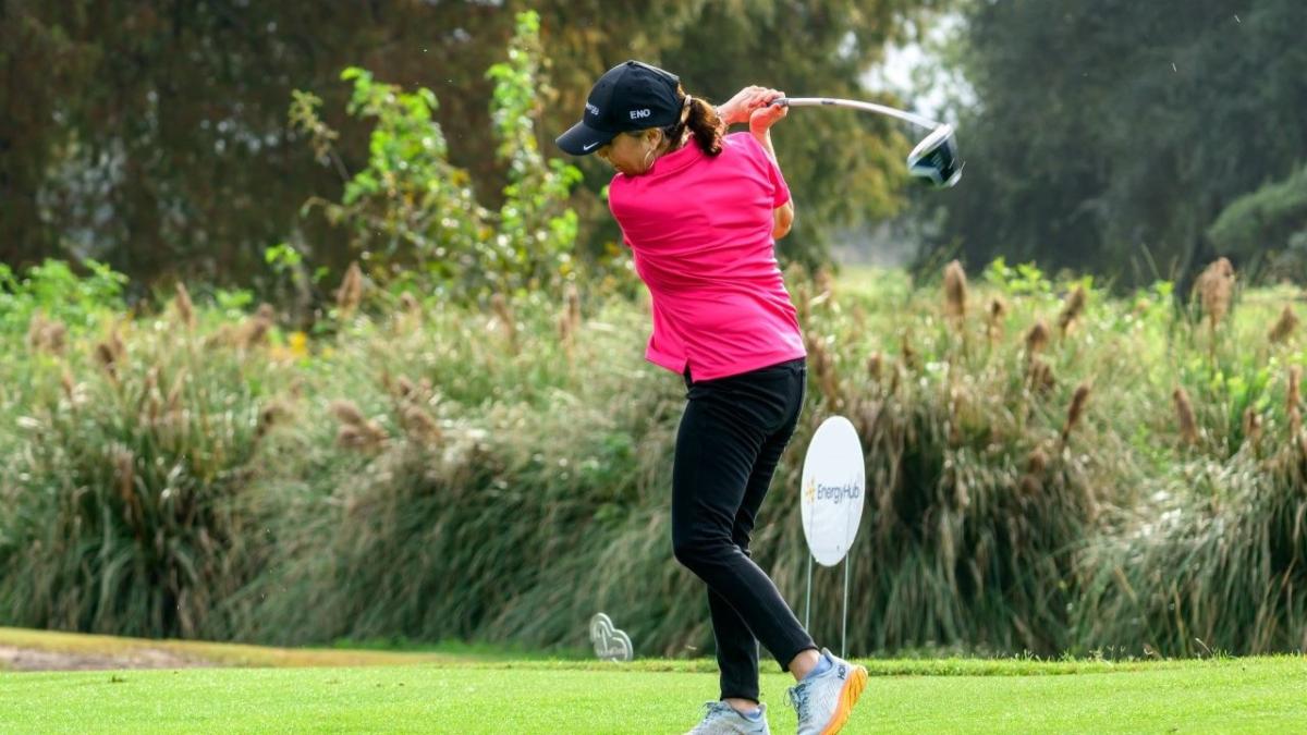 A person swinging a golf club on a course