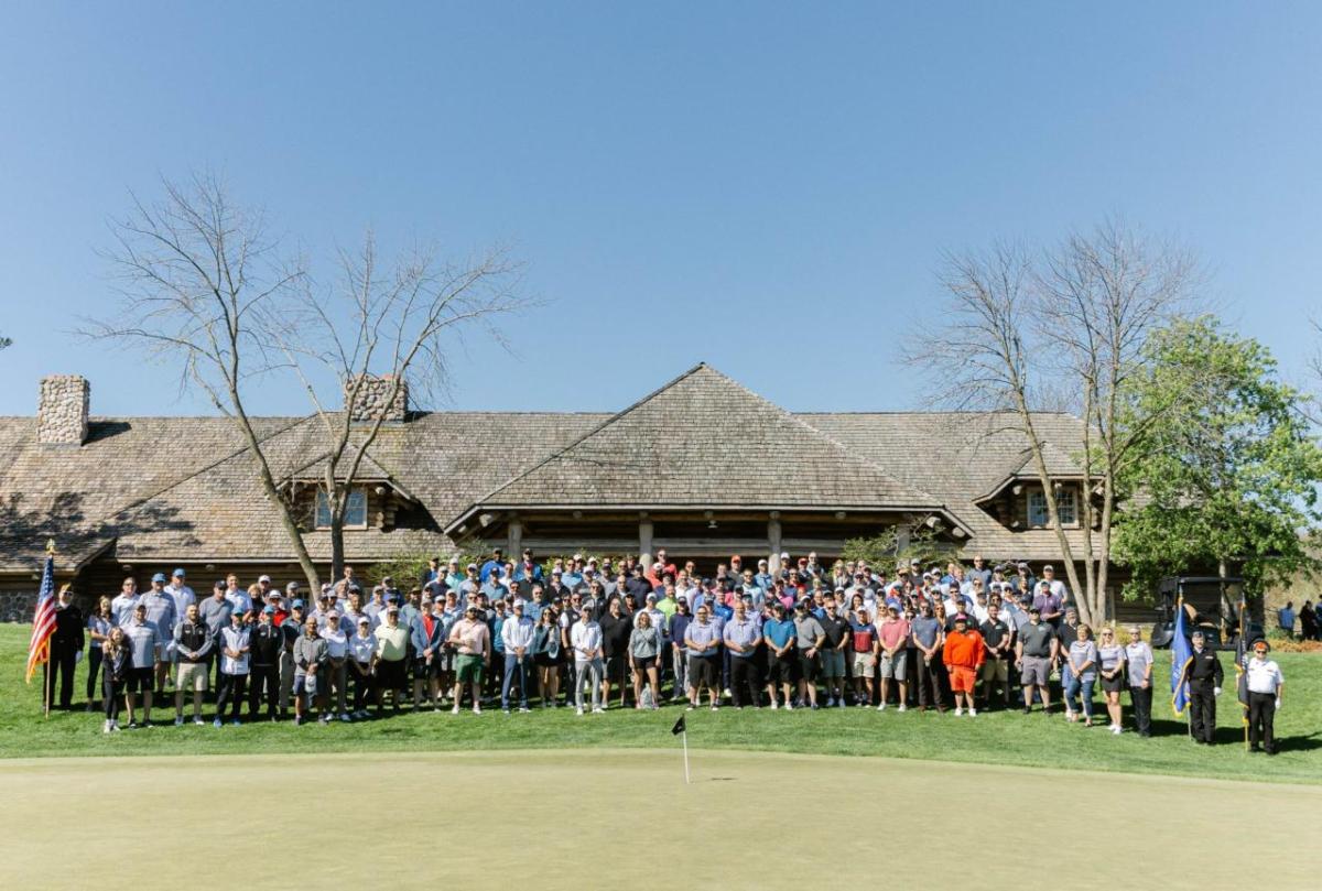 A large group posed on a golf course.