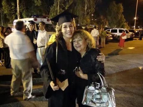 Evila Melgoza in cap and gown hugging another person.