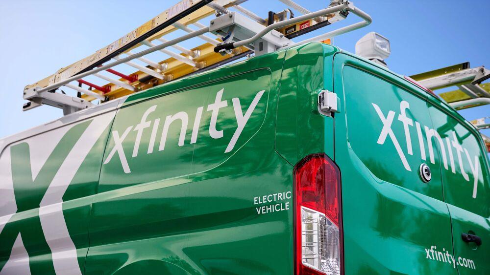 The side of a green xfinity truck with ladders on top