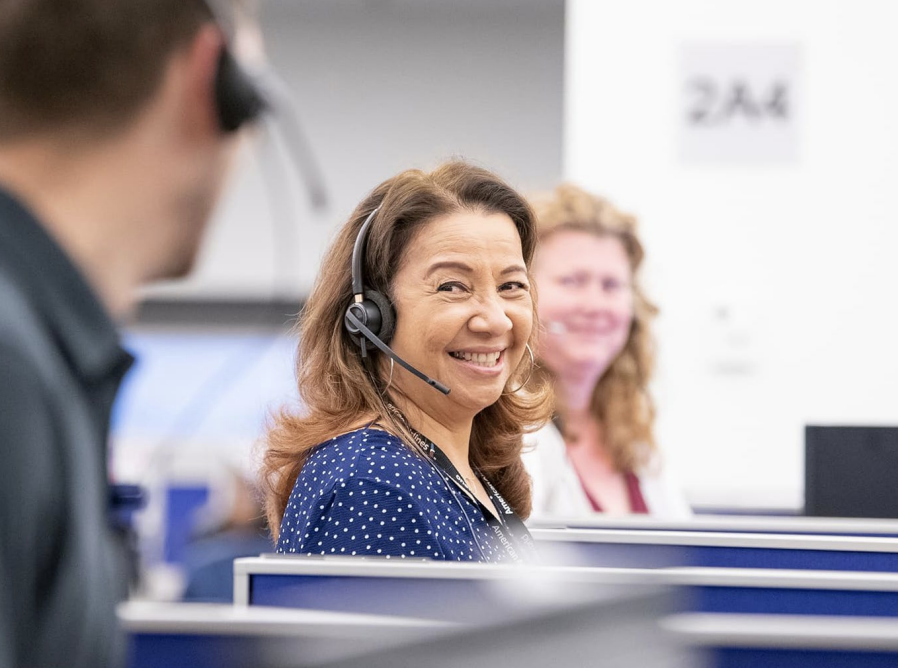 People wearing headsets smiling at each other 