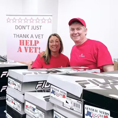 Kimberlie Calderone and Cathleen Kennedy standing behind stacks of shoe boxes.