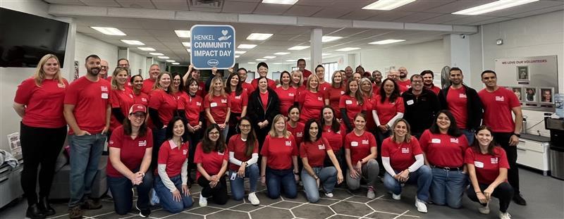 A large group of volunteers posed in an office setting.