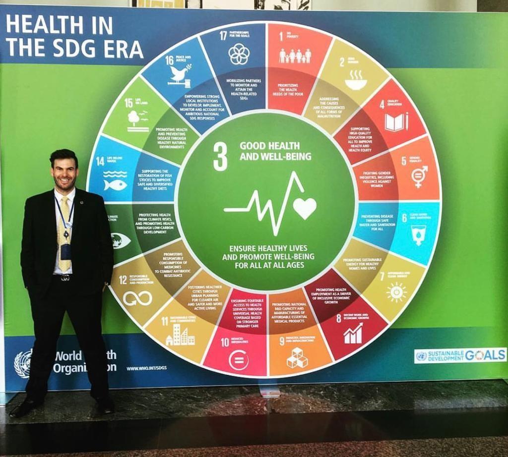 James Pfitzer stood next to a 'Health in the SDG era' board