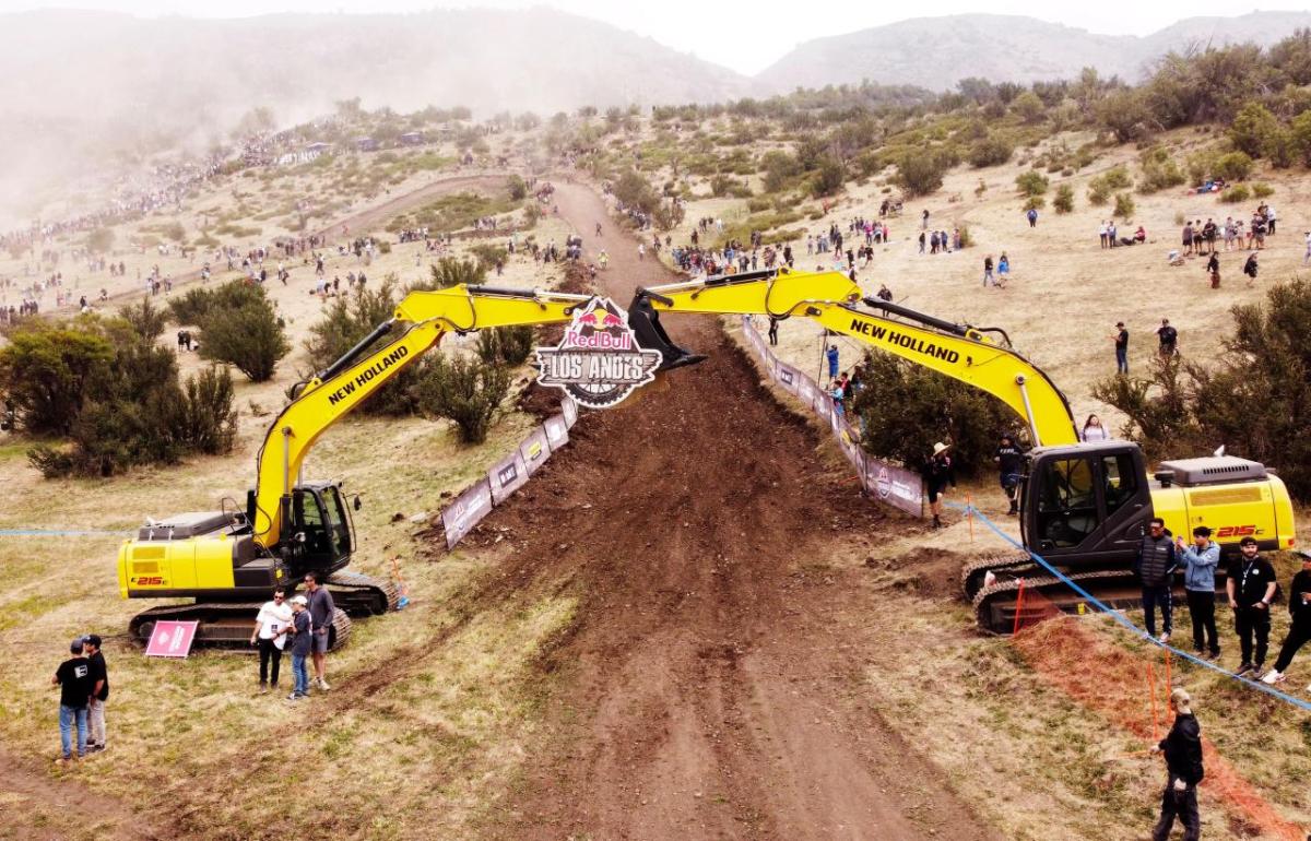 Two large excavators with booms extended over a long dirt path.