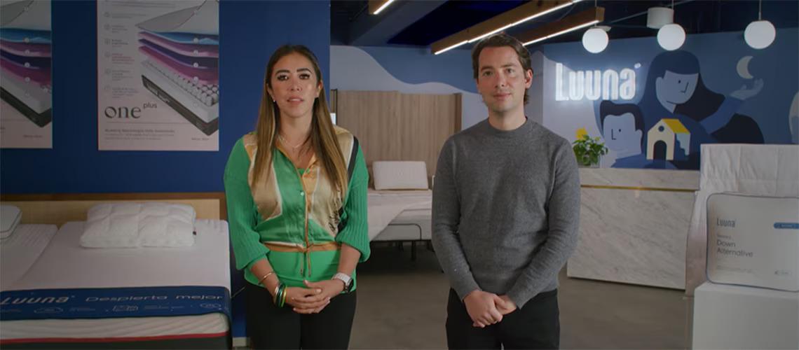 Two people standing in a mattress showroom.