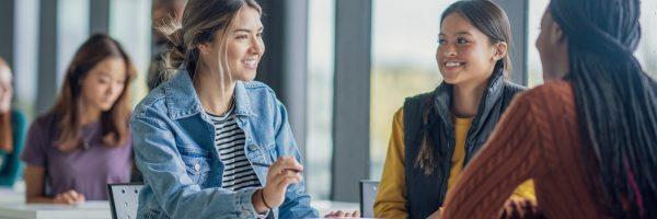 Smiling people talking at a table.