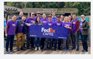 A group of volunteers posed outside with a FedEx Cares sign.