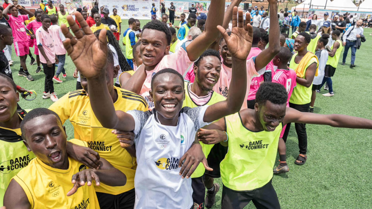 A group of people outside in bright athletic shirts celebrating