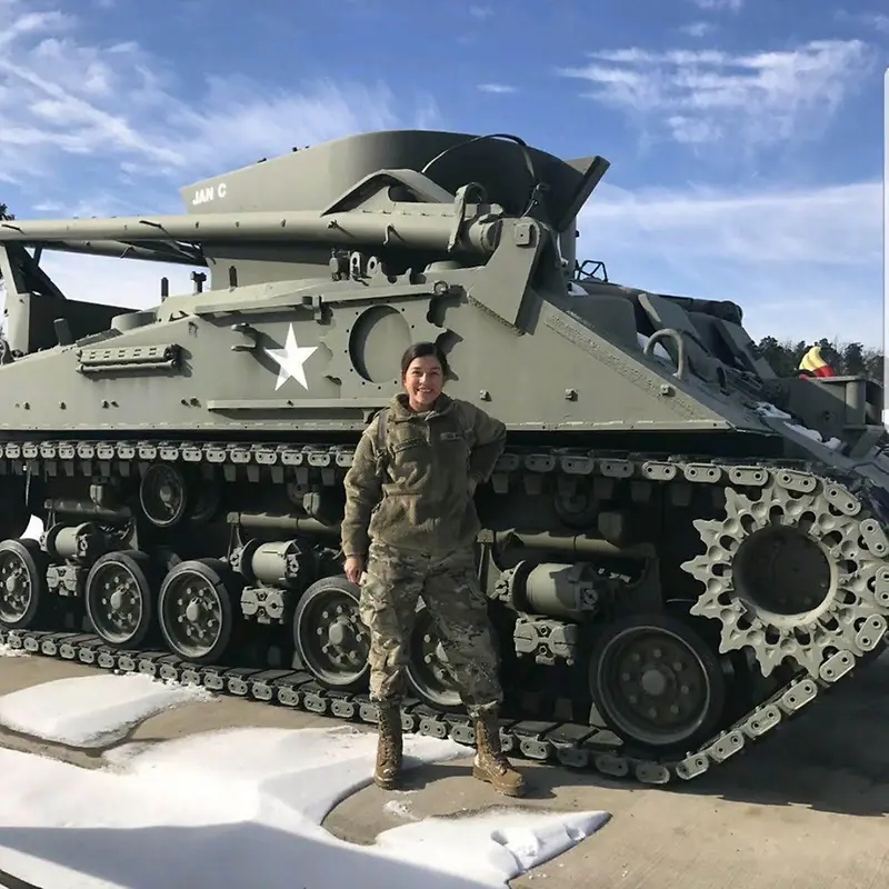 Dapnee standing in front of a tank
