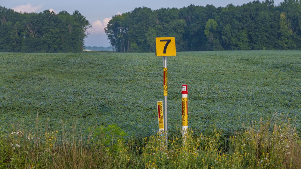 A pipeline marker in a large field.