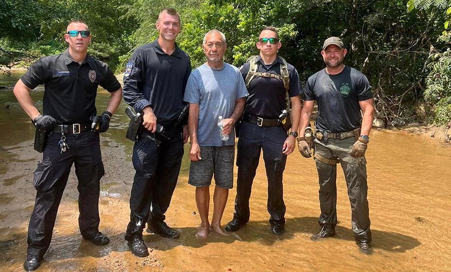 Four police officers posed with the missing man, standing in water.