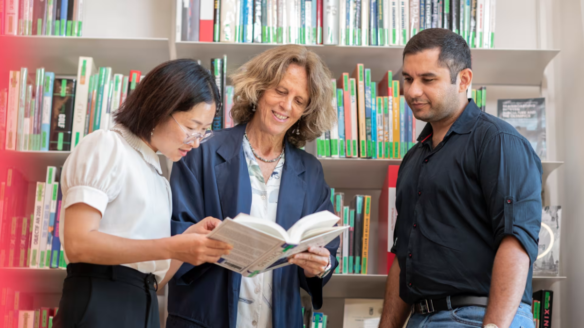 Three people reading a book