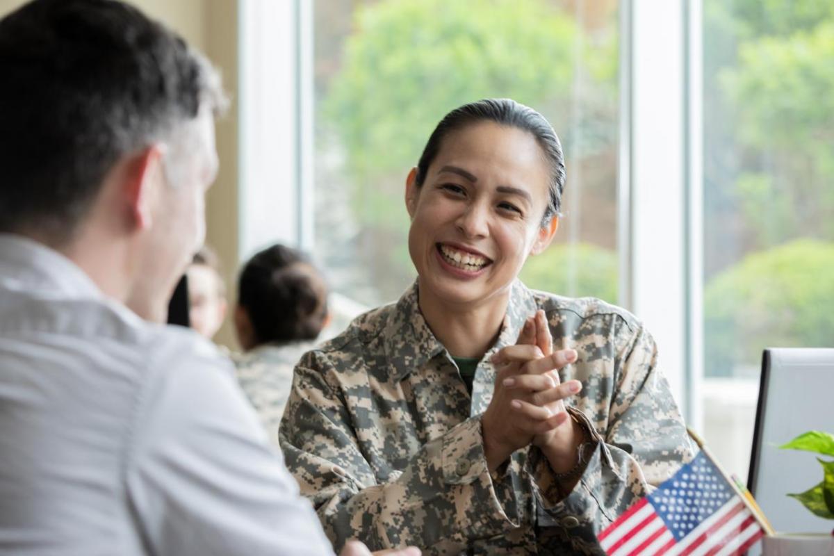 A smiling service member talking with someone