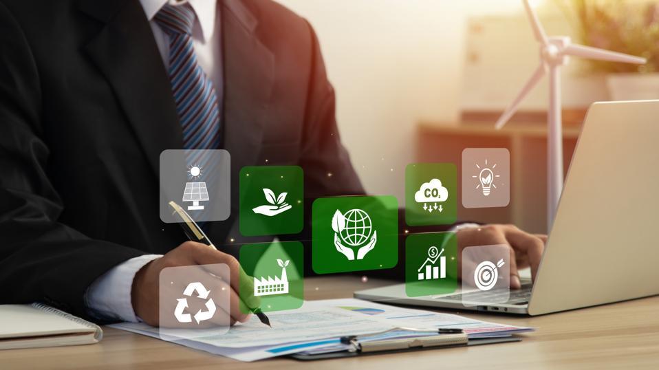 As climate adaptation and mitigation climb up corporate priority lists, the agenda of today’s COO is shifting. GETTY writing on a desk while typing on a laptop