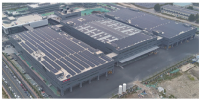 Aerial view of a large building with solar panels on the roof.