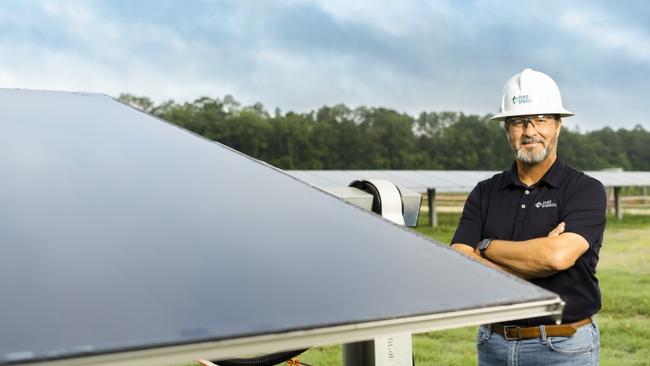 Duke Energy employee standing next to a solar panel