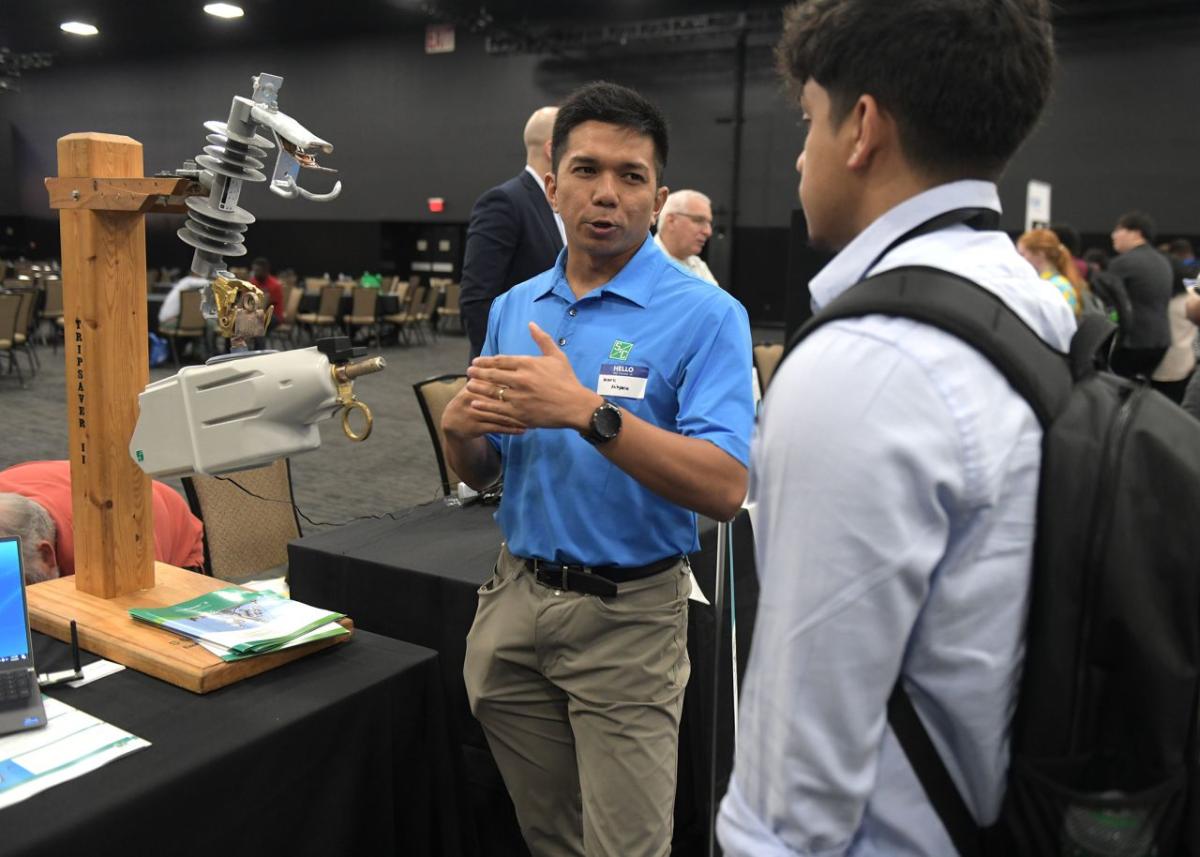 A person showing a student a piece of equipment.