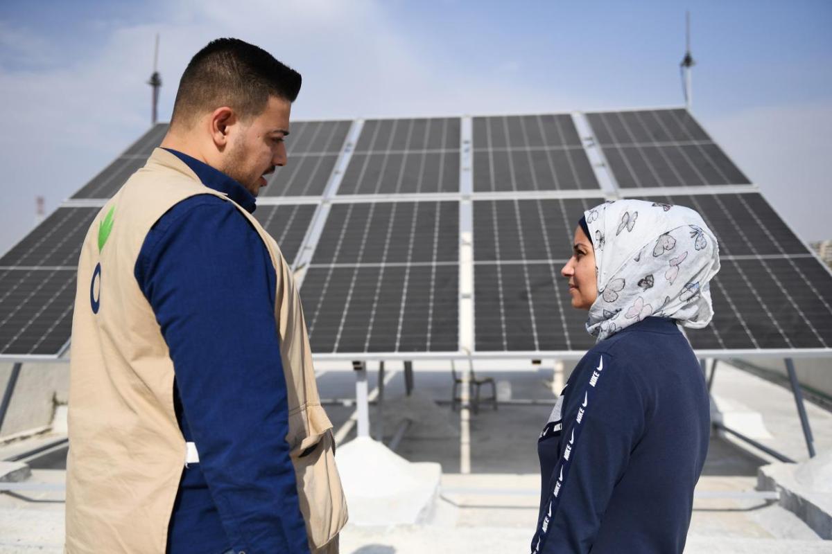 Action Against Hunger's Abdul Kareem, 28, works on a solar electricity project with Amira, the manager of a local school in Aleppo.