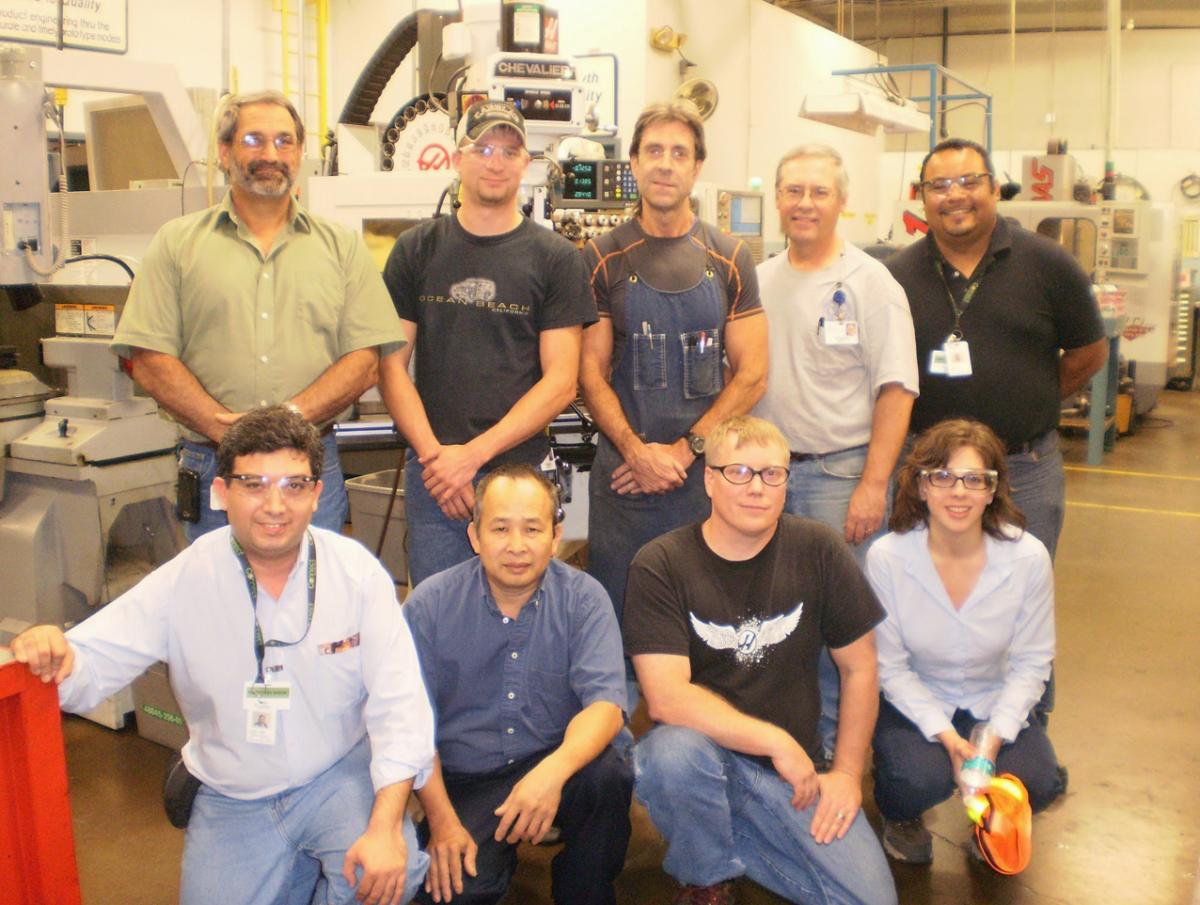 Team of employees posed in a warehouse setting.