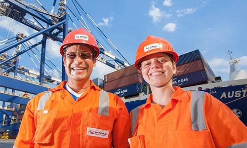 Two DP World employees in uniform at a shipping transfer yard.