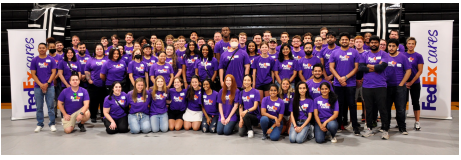 A large group posed in matching FedEx Cares shirts.