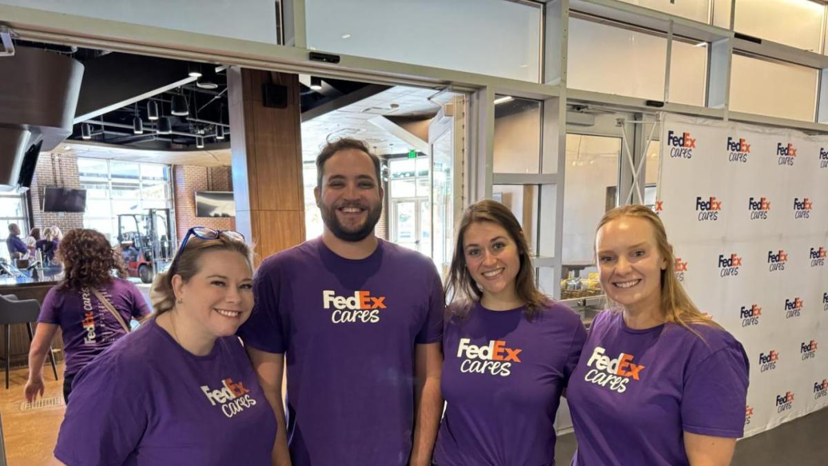 Four smiling people in FedEx Cares t-shirts