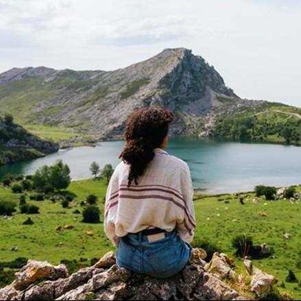 A person looking out over a mountain and lake scenery.