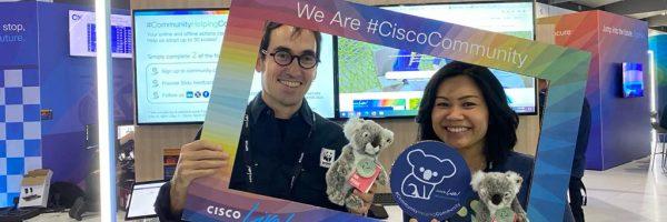 Two people holding up a colorful frame "We Are Cisco Community". Each holding a stuffed koala.